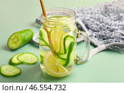 Стеклянная банка с пропитанной водой с ломтями огурца и сетчатый мешок на зеленом фоне. Стоковое фото, фотограф Pixel_shot / Фотобанк Лори