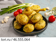 Тарелка отварных маленьких картофелин с укропом и соусом на голубом фоне. Стоковое фото, фотограф Pixel_shot / Фотобанк Лори