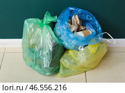 Полные мусорные мешки рядом с зеленой стеной. Стоковое фото, фотограф Pixel_shot / Фотобанк Лори