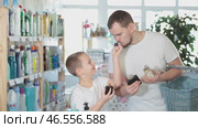 Dad and son client sniffs fragrance of perfume, chooses scent spray with pleasant smell. Стоковое видео, видеограф Яков Филимонов / Фотобанк Лори
