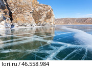 Baikal Lake in February sunny day. Beautiful winter landscape with blue smooth ice with cracks near Shibete mountain at Ust-Anga Bay. Natural background. Ice travels and outdoor recreation. Стоковое фото, фотограф Виктория Катьянова / Фотобанк Лори