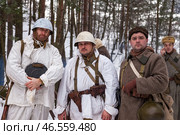 Sestroretsk, Russia - February 19, 2023: Soldiers dressed in winter attire gather outdoors in a snow-covered forest, embodying resilience as they recreate the atmosphere of historical battles. Редакционное фото, фотограф Aleksandr Golubev / Фотобанк Лори
