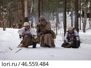 Sestroretsk, Russia - February 19, 2023: Soldiers in period-appropriate attire engage in a winter battle reenactment, showcasing tactical maneuvers amidst a snowy forest landscape during World War Two. Редакционное фото, фотограф Aleksandr Golubev / Фотобанк Лори