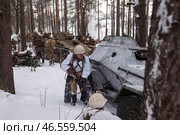 Sestroretsk, Russia - February 19, 2023: Soldiers in winter gear engage in a tactical exercise amidst snow-covered trees and military vehicles, depicting the grit of Second World War battles. Редакционное фото, фотограф Aleksandr Golubev / Фотобанк Лори