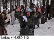 Sestroretsk, Russia - February 19, 2023: Soldiers reenacting the winter battle of the Second World War raise their hands in surrender amid a snowy forest setting, capturing the intensity of warfare. Редакционное фото, фотограф Aleksandr Golubev / Фотобанк Лори