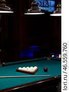 Russian billiards. Red and white balls are lying on a green billiard table. Spending time at home playing a hobby sports game. Стоковое фото, фотограф Photojuli / Фотобанк Лори