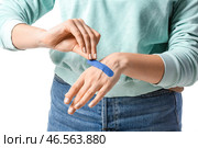 Молодая женщина накладывает медицинский пластырь на белом фоне, крупным планом. Стоковое фото, фотограф Pixel_shot / Фотобанк Лори