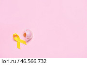 Золотая лента осознания и соска на цветном фоне. Международный день защиты от рака. Стоковое фото, фотограф Pixel_shot / Фотобанк Лори