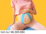 Спортивная беременная женщина с кинезио тейпом на цветном фоне. Стоковое фото, фотограф Pixel_shot / Фотобанк Лори
