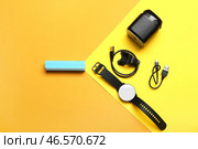 Внешний аккумулятор с USB-кабелем, умными часами и динамиком на цветном фоне. Стоковое фото, фотограф Pixel_shot / Фотобанк Лори