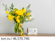 Ваза с красивыми цветами и кубический календарь с датой 8 МАРТА на кухонном столе возле светлой стены. Празднование Международного женского дня. Стоковое фото, фотограф Pixel_shot / Фотобанк Лори