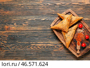 Доска с вкусной узбекской самсой на деревянном фоне. Стоковое фото, фотограф Pixel_shot / Фотобанк Лори