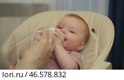 Feeding a baby from a bottle with infant formula. Стоковое видео, видеограф Михаил Матвеев / Фотобанк Лори