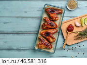 Форма для запекания с жареными куриными крылышками на цветном деревянном фоне. Стоковое фото, фотограф Pixel_shot / Фотобанк Лори