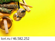 Тибетская поющая чаша, караталы, пало-санто и травы для очищения ауры на цветном фоне. Стоковое фото, фотограф Pixel_shot / Фотобанк Лори