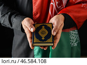 Мужчина с флагом Афганистана и Кораном на темном фоне, крупным планом. Стоковое фото, фотограф Pixel_shot / Фотобанк Лори