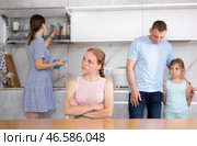 Aggrieved teenage girl listening to reprimand of father in kitchen. Стоковое фото, фотограф Яков Филимонов / Фотобанк Лори