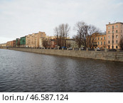 Sankt-Petersburg, Russia 01.19.25: A serene view of a river Obvodny Canal reflecting soft light of late afternoon. Historical buildings line waterfront, showcasing architectural details and city life. Редакционное фото, фотограф Юлия Петровская / Фотобанк Лори