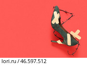 Туфли на высоком каблуке с лейкопластырями и колючей проволокой на красном фоне. Концепция неудобных туфель. Стоковое фото, фотограф Pixel_shot / Фотобанк Лори