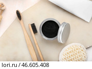 Баночка с зубным порошком с активированным углем и зубными щетками на светлом фоне. Стоковое фото, фотограф Pixel_shot / Фотобанк Лори