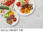 Тарелки шашлыка с вкусным люля-кебабом и овощами на светлом фоне. Стоковое фото, фотограф Pixel_shot / Фотобанк Лори