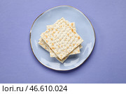 Тарелка с еврейскими лепешками на Песах на цветном фоне. Стоковое фото, фотограф Pixel_shot / Фотобанк Лори