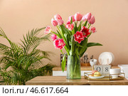 Красивые тюльпаны, поднос с макаронами, чашка и кубический календарь с датой 8 МАРТА на столе на кухне. Празднование Международного женского дня. Стоковое фото, фотограф Pixel_shot / Фотобанк Лори