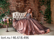 Elegant Fashion Moment Captured Indoors With a Stunning Gown Against a Rustic Backdrop. Стоковое фото, фотограф Aleksandr Golubev / Фотобанк Лори