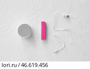 Розовый блок питания с USB-кабелем и динамиком на белом фоне. Стоковое фото, фотограф Pixel_shot / Фотобанк Лори
