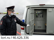 Полицейский у отсека для задержанных служебного автомобиля (2020 год). Редакционное фото, фотограф Free Wind / Фотобанк Лори