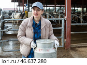 Milkmaid with aluminium cans near open cowshed at dairy farm. Стоковое фото, фотограф Яков Филимонов / Фотобанк Лори