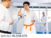 Young karate fighter working on punches in sparring with master at training. Стоковое фото, фотограф Яков Филимонов / Фотобанк Лори