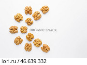 Вкусные грецкие орехи с текстом ОРГАНИЧЕСКИЙ СНЕК на белом фоне. Стоковое фото, фотограф Pixel_shot / Фотобанк Лори