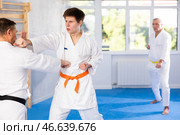Young karate fighter working on punches in sparring with master at training. Стоковое фото, фотограф Яков Филимонов / Фотобанк Лори