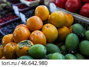 Свежие хурма и фейхоа на прилавке рынка. Стоковое фото, фотограф Софья Сандурская / ТАСС / Фотобанк Лори