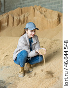Woman livestock farm owner checking soybean husk for cattle feeding. Стоковое фото, фотограф Яков Филимонов / Фотобанк Лори