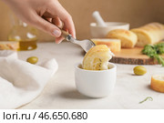Женщина макает хлеб в миску с вкусными оливками, крупным планом. Стоковое фото, фотограф Pixel_shot / Фотобанк Лори