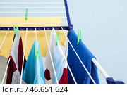 Чистая одежда висит на сушилке на цветном фоне, крупным планом. Стоковое фото, фотограф Pixel_shot / Фотобанк Лори