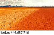 Vast cracked earth stretches across the desert landscape. Стоковое AI-изображение, AI-художник Татьяна  Бральнина / Фотобанк Лори