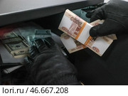Банкноты из вскрытого сейфа в руках вора в черных кожаных перчатках. Стоковое фото, фотограф Сергей Булкин/NEWS.ru / ТАСС / Фотобанк Лори