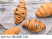 Вкусные круассаны с шоколадным сиропом на деревянном столе. Стоковое фото, фотограф Pixel_shot / Фотобанк Лори