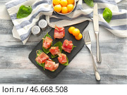 Вкусные шарики дыни с прошутто на грифельной тарелке. Стоковое фото, фотограф Pixel_shot / Фотобанк Лори