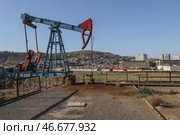 Нефтяной станок-качалка на фоне города. Стоковое фото, фотограф Сергей Булкин/NEWS.ru / ТАСС / Фотобанк Лори