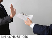 Бизнесмен отказывается принимать взятки на светлом фоне. Понятие коррупции. Стоковое фото, фотограф Pixel_shot / Фотобанк Лори