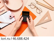 Женщина с различной канцелярией, использующая калькулятор на цветном фоне. Стоковое фото, фотограф Pixel_shot / Фотобанк Лори