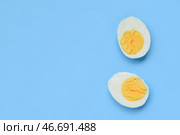 Половинки вкусного отваренного яйца на голубом фоне. Стоковое фото, фотограф Pixel_shot / Фотобанк Лори