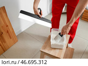 Мужской декоратор с шпателями работает в комнате, крупным планом. Стоковое фото, фотограф Pixel_shot / Фотобанк Лори