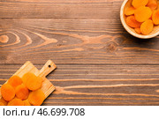 Доска и чашка с вкусными курагой на деревянном фоне. Стоковое фото, фотограф Pixel_shot / Фотобанк Лори