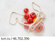 Стринг-сумка с свежими помидорами на белом фоне. Стоковое фото, фотограф Pixel_shot / Фотобанк Лори