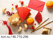 Китайские символы с печеньями с предсказаниями, красным конвертом и мандаринами на белом фоне с эффектом состаривания. Празднование Нового года. Стоковое фото, фотограф Pixel_shot / Фотобанк Лори